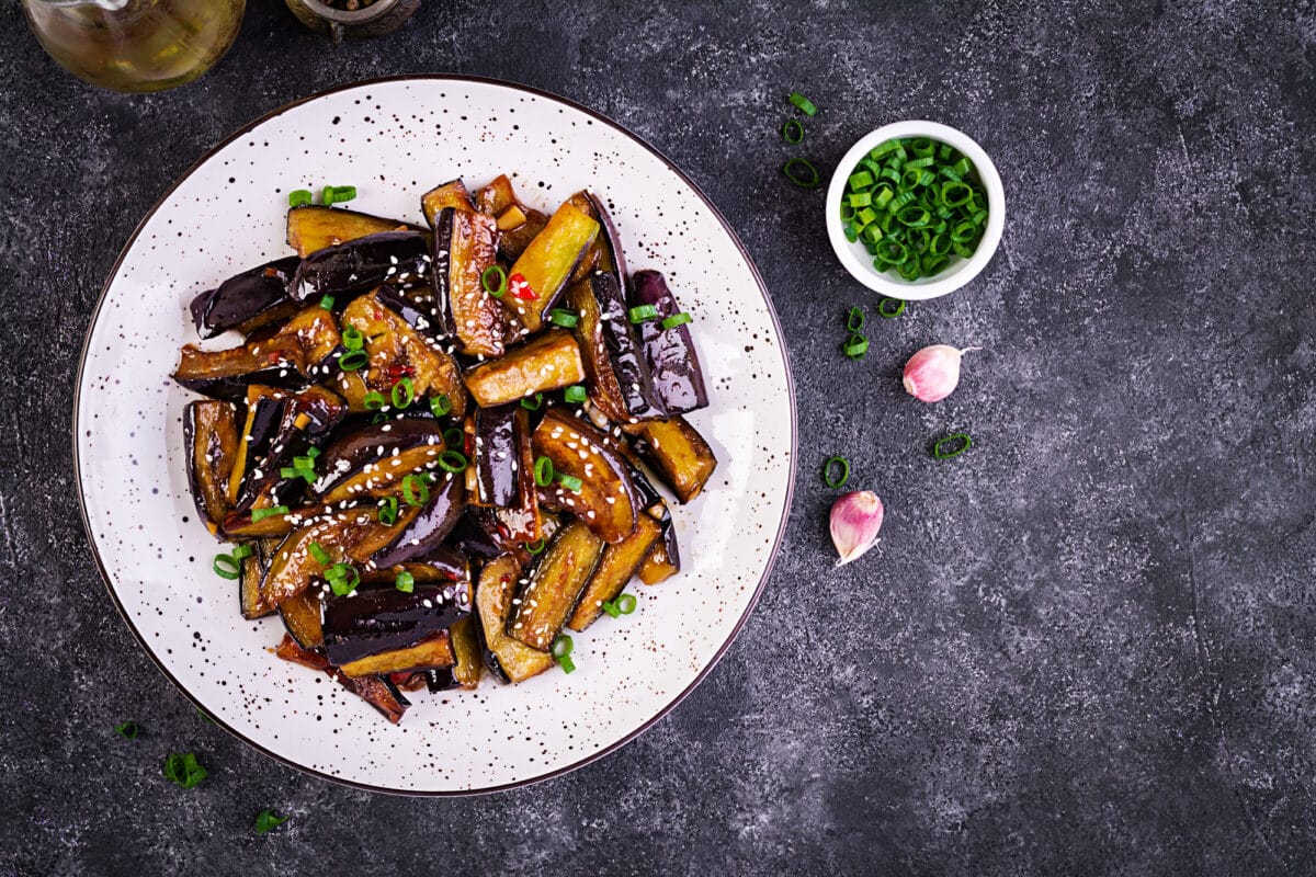 Nasu dengaku : savoureuse aubergine garnie de viande hachée, rehaussée par du piment chinois mariné, vinaigre de riz noir, vin de riz Shaoxing, une pointe de sucre, sauce soja foncée, et parfumée à l'huile de sésame, ail, gingembre et oignons verts